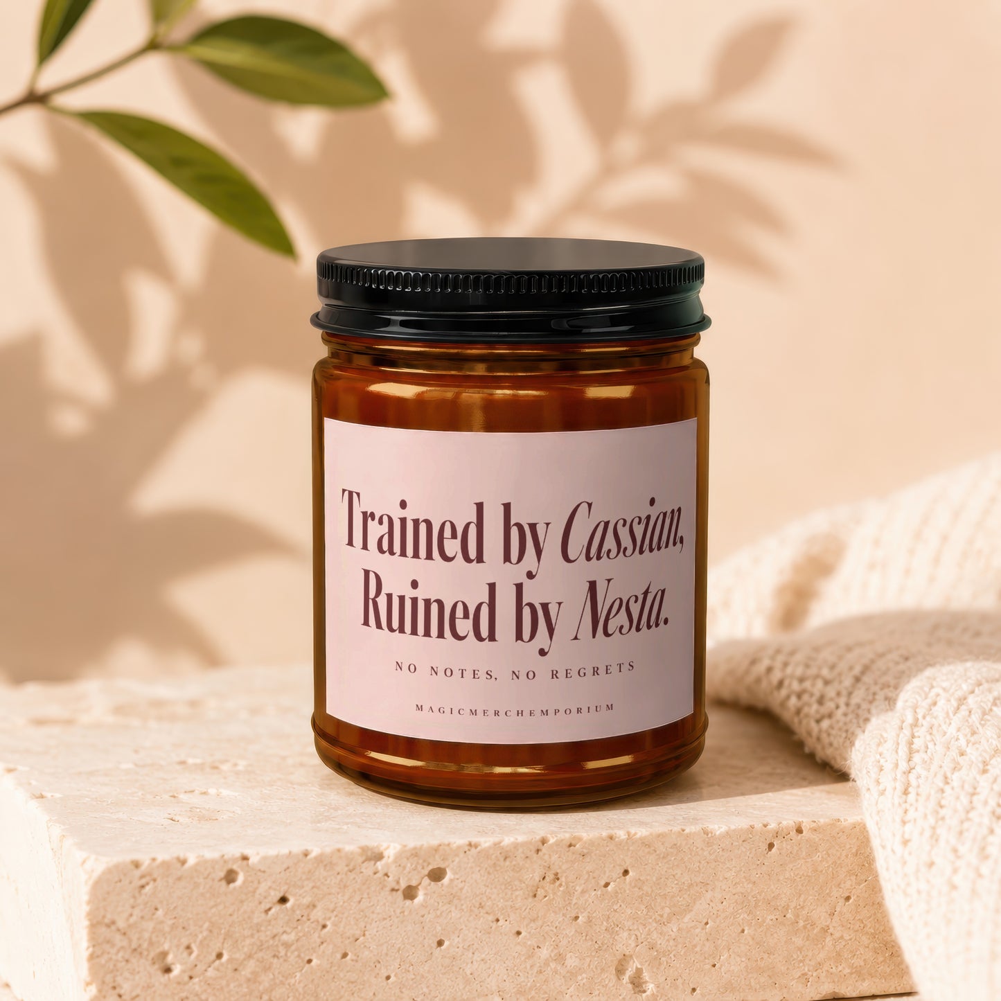 Amber jar candle with black lid, "Trained by Cassian, Ruined by Nesta" text.