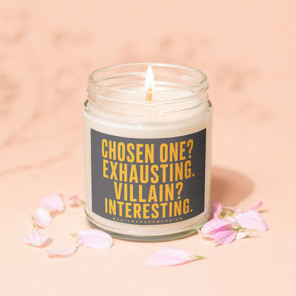 Glass jar candle with burning wick, featuring text "Chosen one? Exhausting. Villain? Interesting."