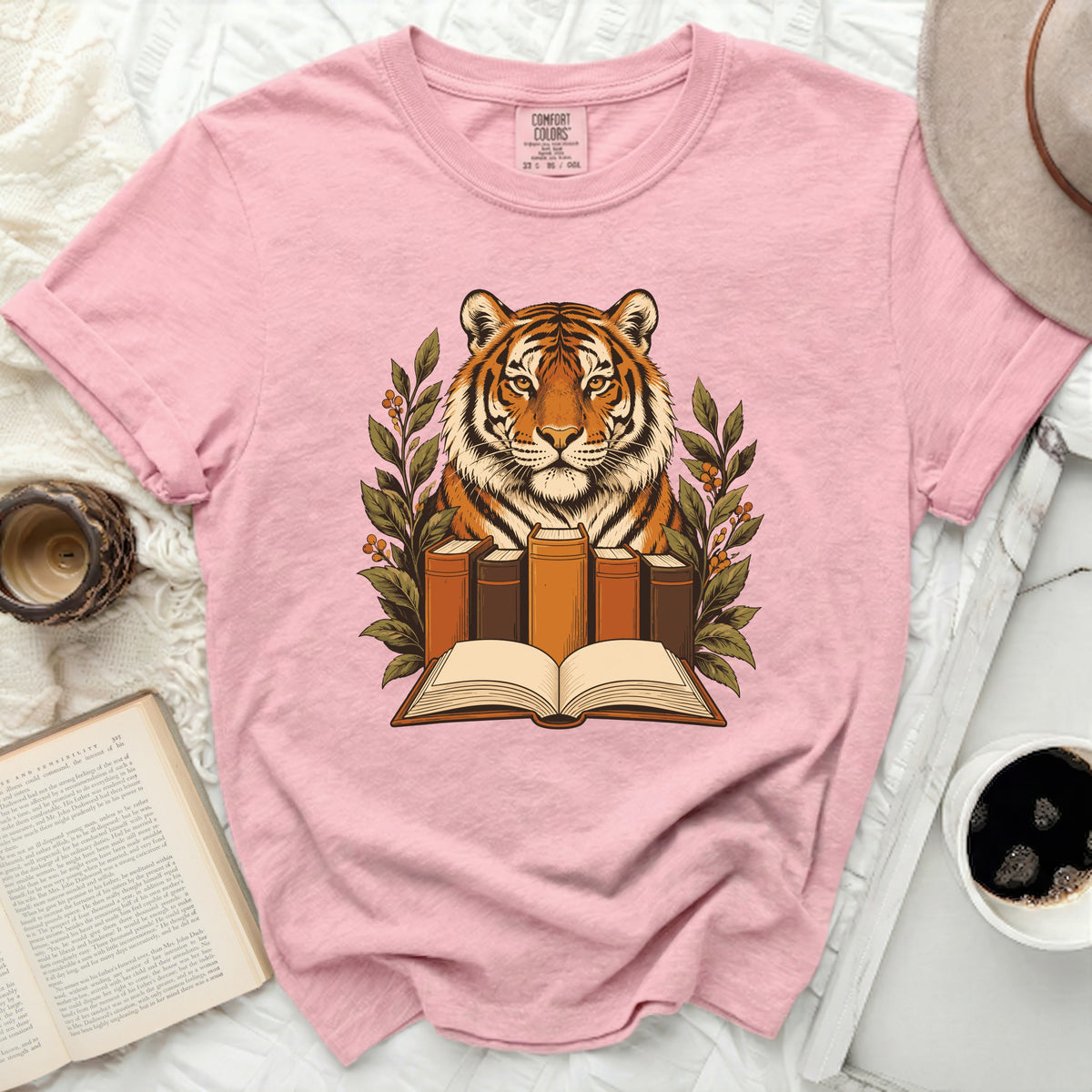 Pink t-shirt with a graphic of a tiger head over an open book and vintage books.