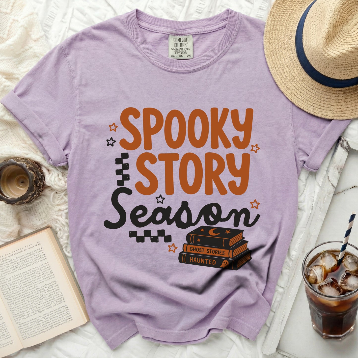 Purple t-shirt with "Spooky Story Season" text and stacked books.