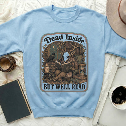 Light blue sweatshirt with a graphic featuring a deer skull reading among books, with text "Dead Inside But Well Read".