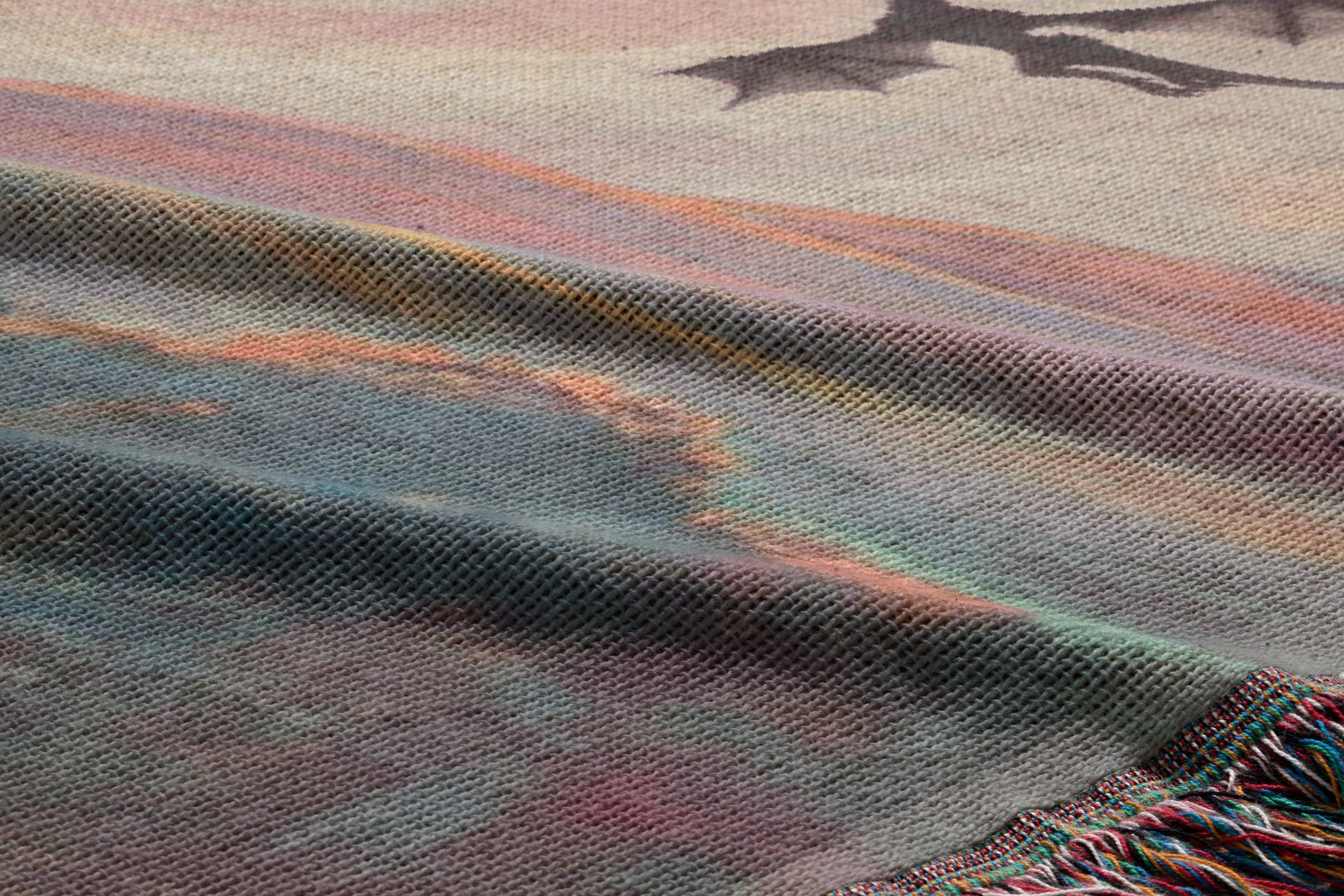a close-up view of a textured fabric with a dragon design on it. The dragon appears to be in flight, and the fabric has a colorful, abstract pattern.