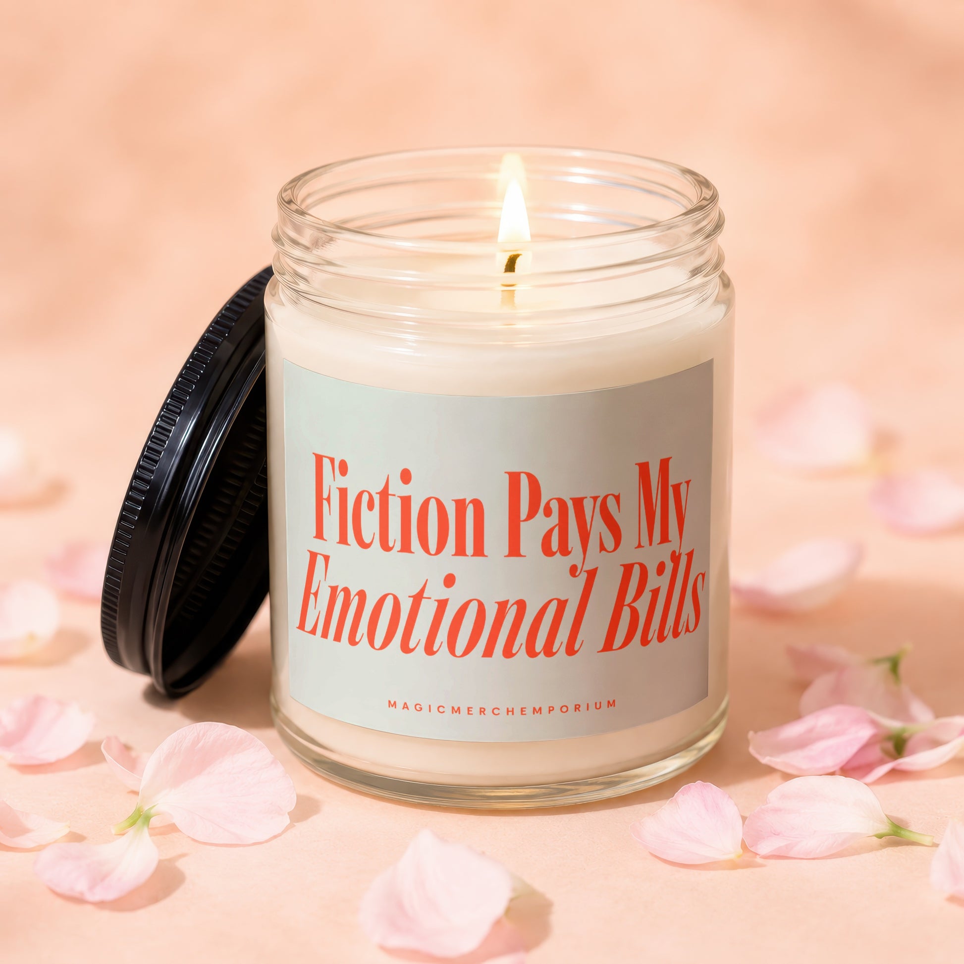 Lit candle in glass jar with lid off, saying "Fiction Pays My Emotional Bills"
