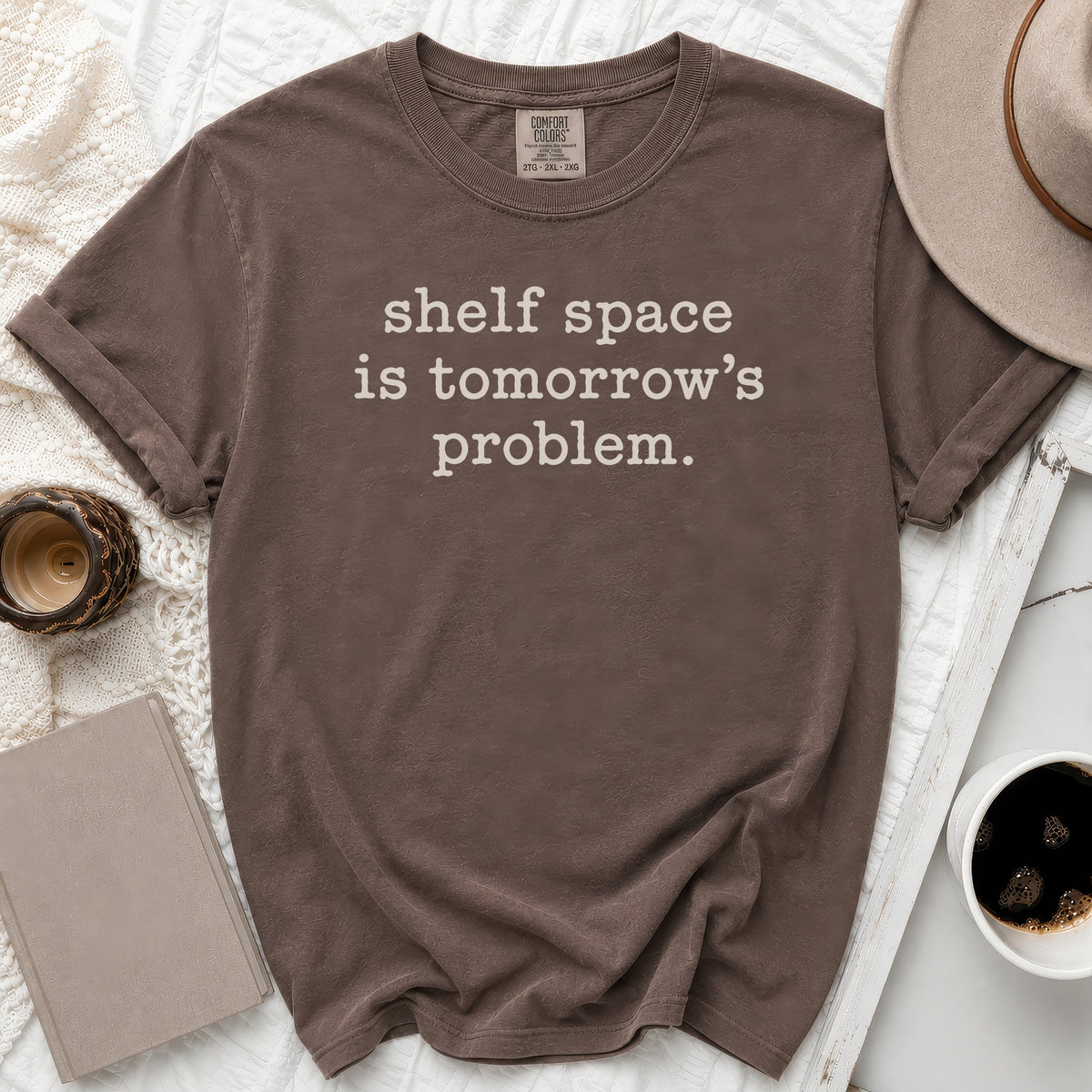 Brown t-shirt with white text "shelf space is tomorrow's problem."