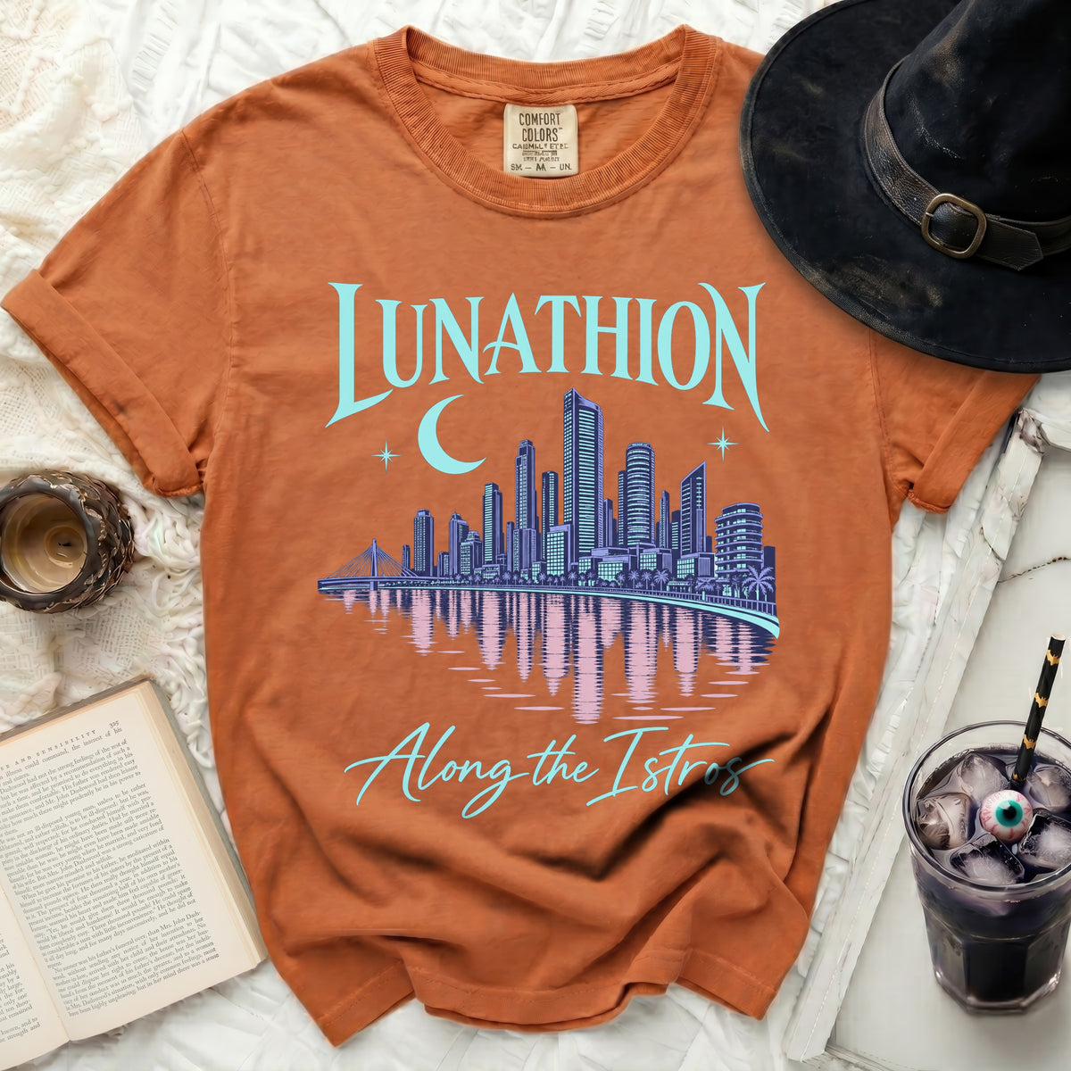 Orange t-shirt with "Lunathion" and a cityscape with moon, "Along the Istros" text.