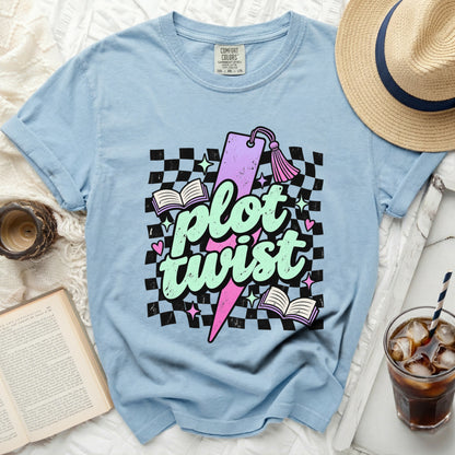 Light blue t-shirt with "plot twist" graphic, books, and checkered background.
