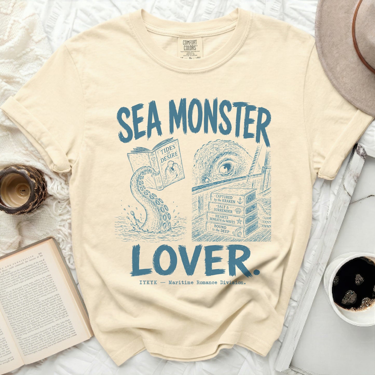 Cream t-shirt with blue "Sea Monster Lover" graphic and book titles.