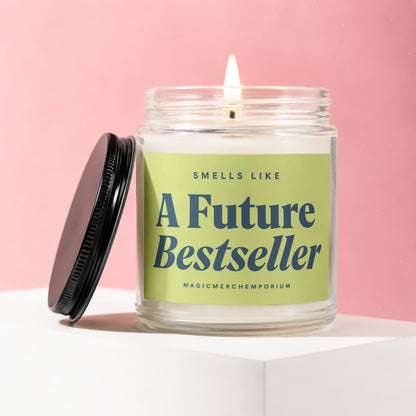 Glass candle with lit wick, green label reads "Smells Like A Future Bestseller".