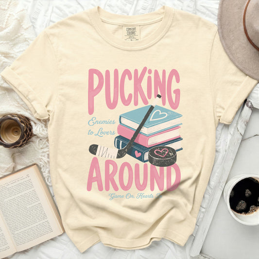 T-shirt with "Pucking Around" text and hockey puck, stick, and puck.