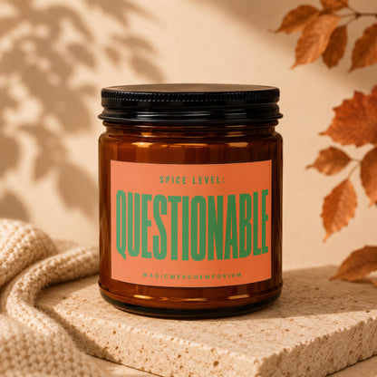 Amber candle in a jar with a black lid, orange label reads "Spice Level: Questionable".