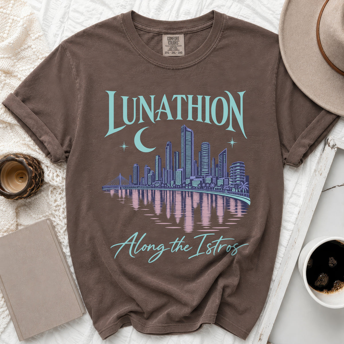 Brown t-shirt with "LUNATHION Along the Istros" text and city skyline graphic.