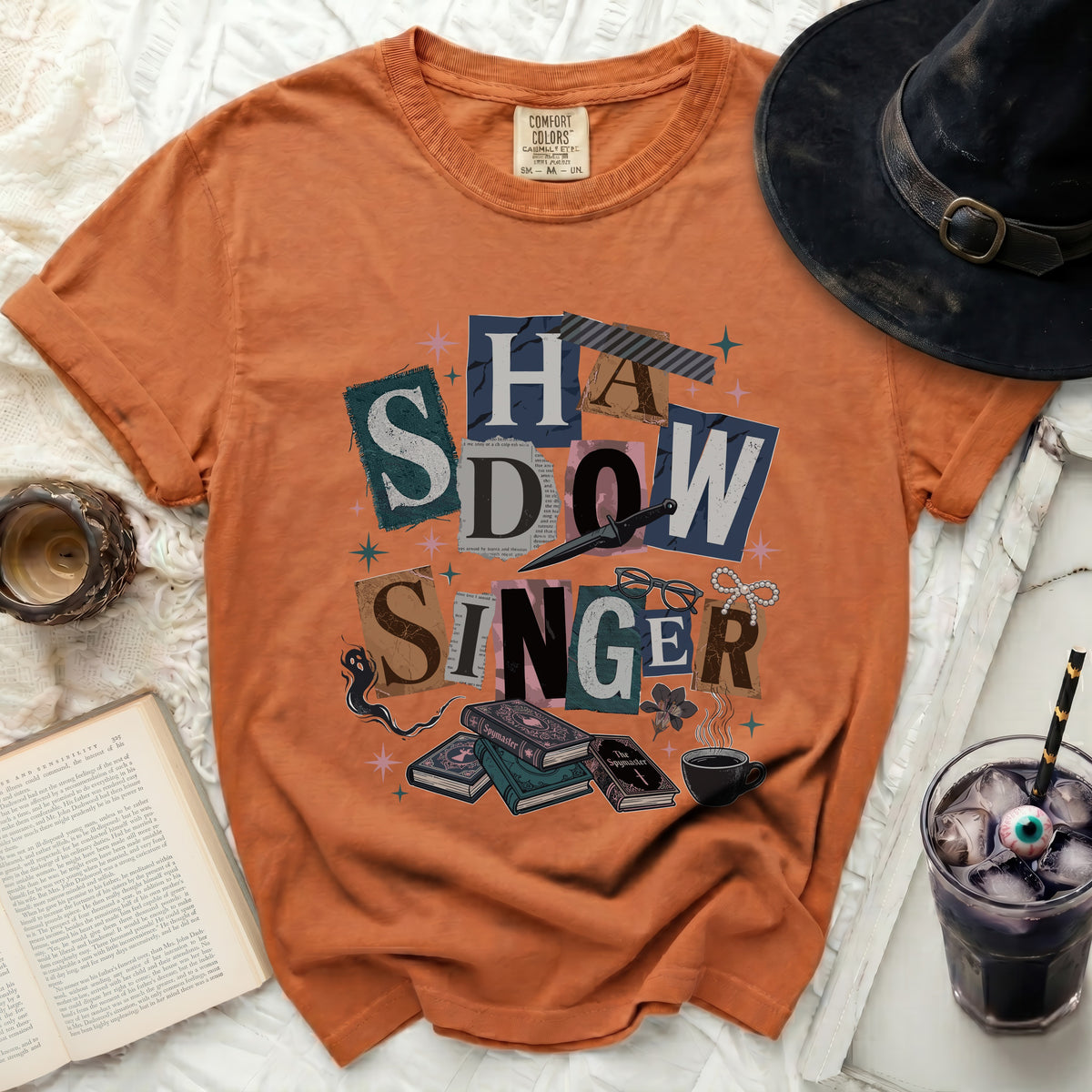 Orange t-shirt with "SHADOW SINGER" collage text and Halloween motifs.