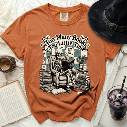 Skeleton reading book surrounded by book titles and text "Too Many Books Too Little Time".