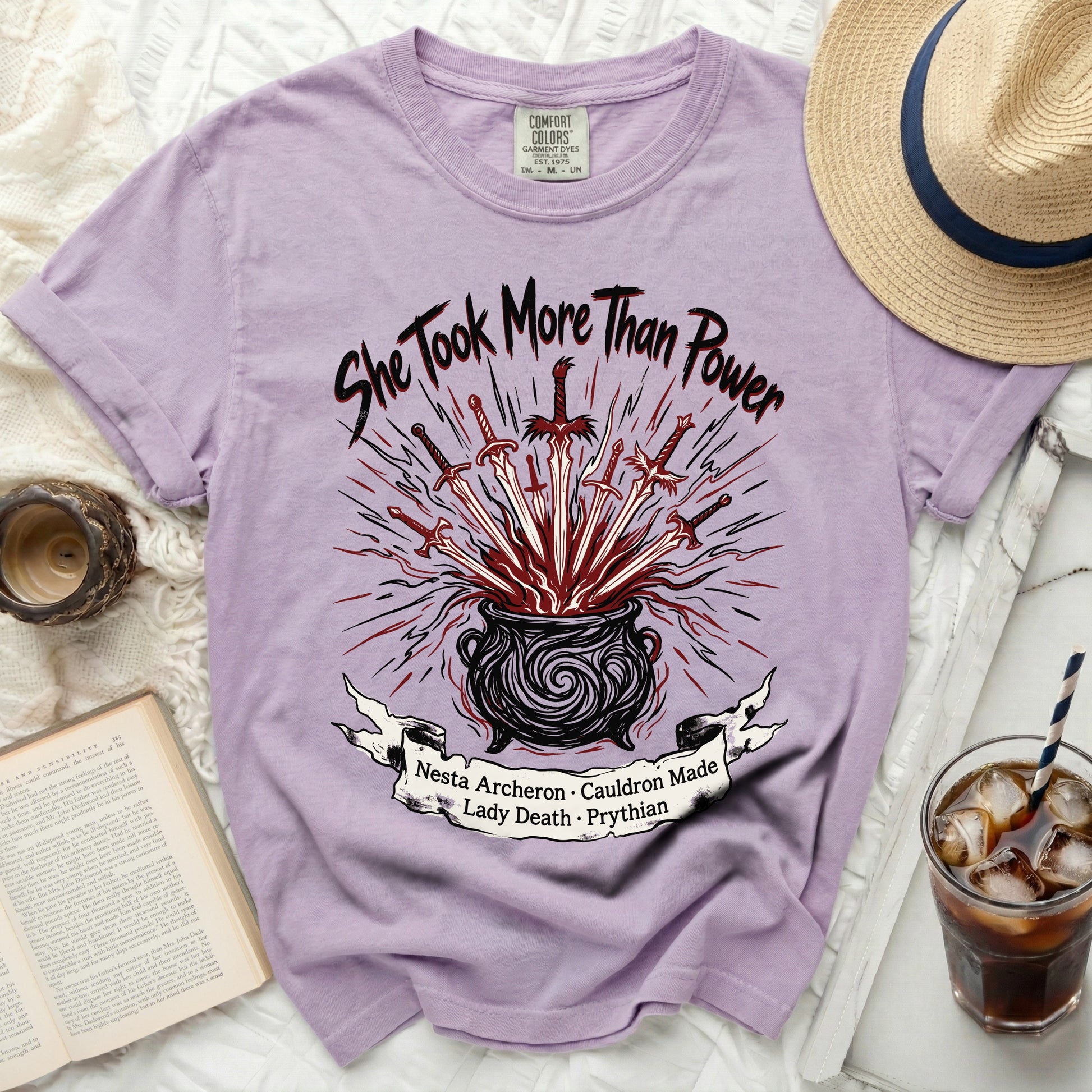 Purple t-shirt with "She Took More Than Power" and cauldron design.