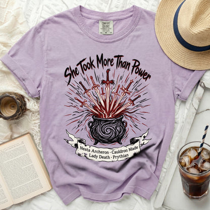 Purple t-shirt with "She Took More Than Power" and cauldron design.
