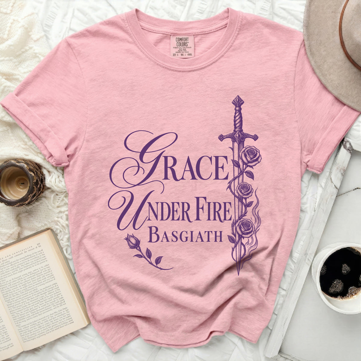 Pink t-shirt with purple text "GRACE UNDER FIRE BASGIATH" and sword graphic.