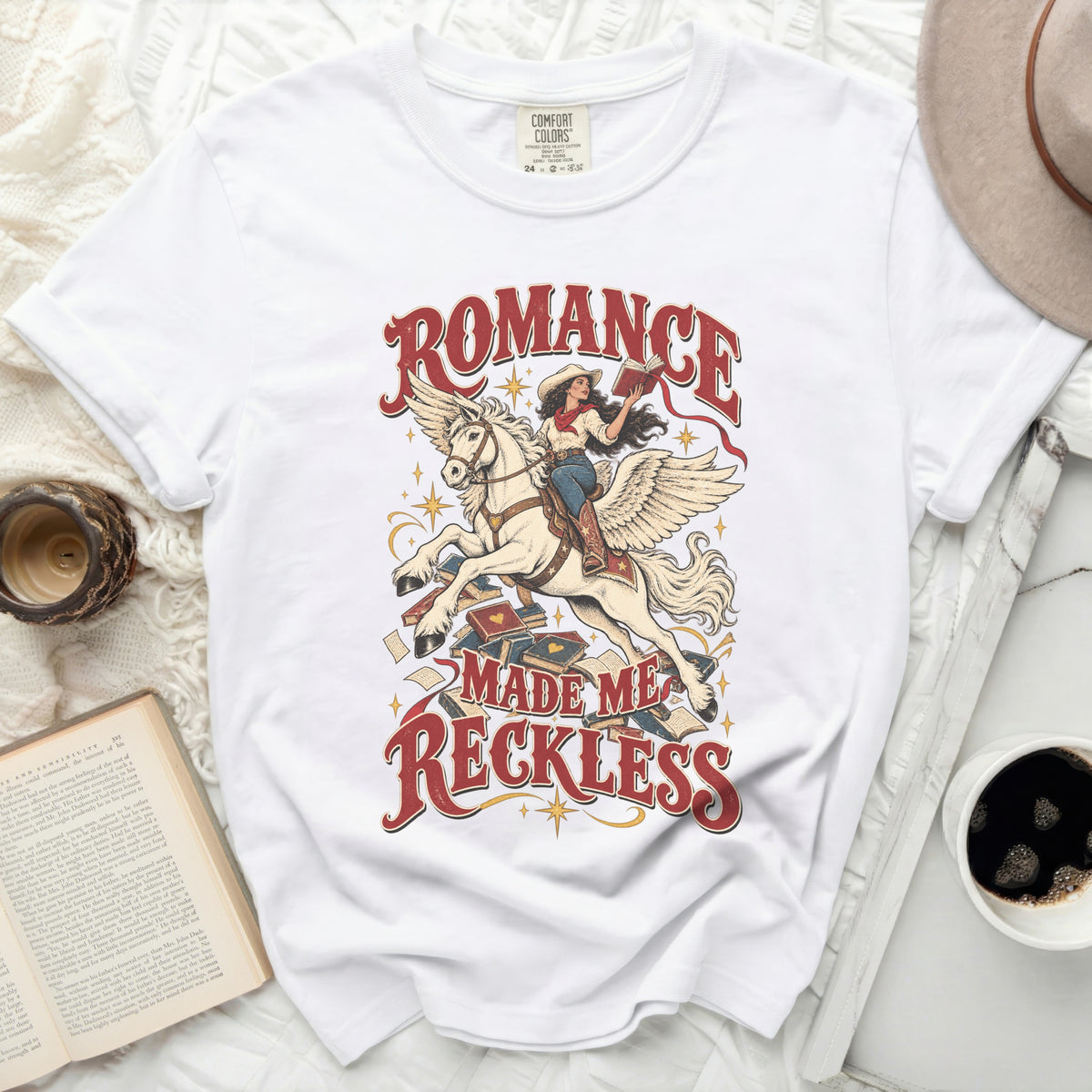 White t-shirt with "Romance Made Me Reckless" text and pegasus rider graphic.