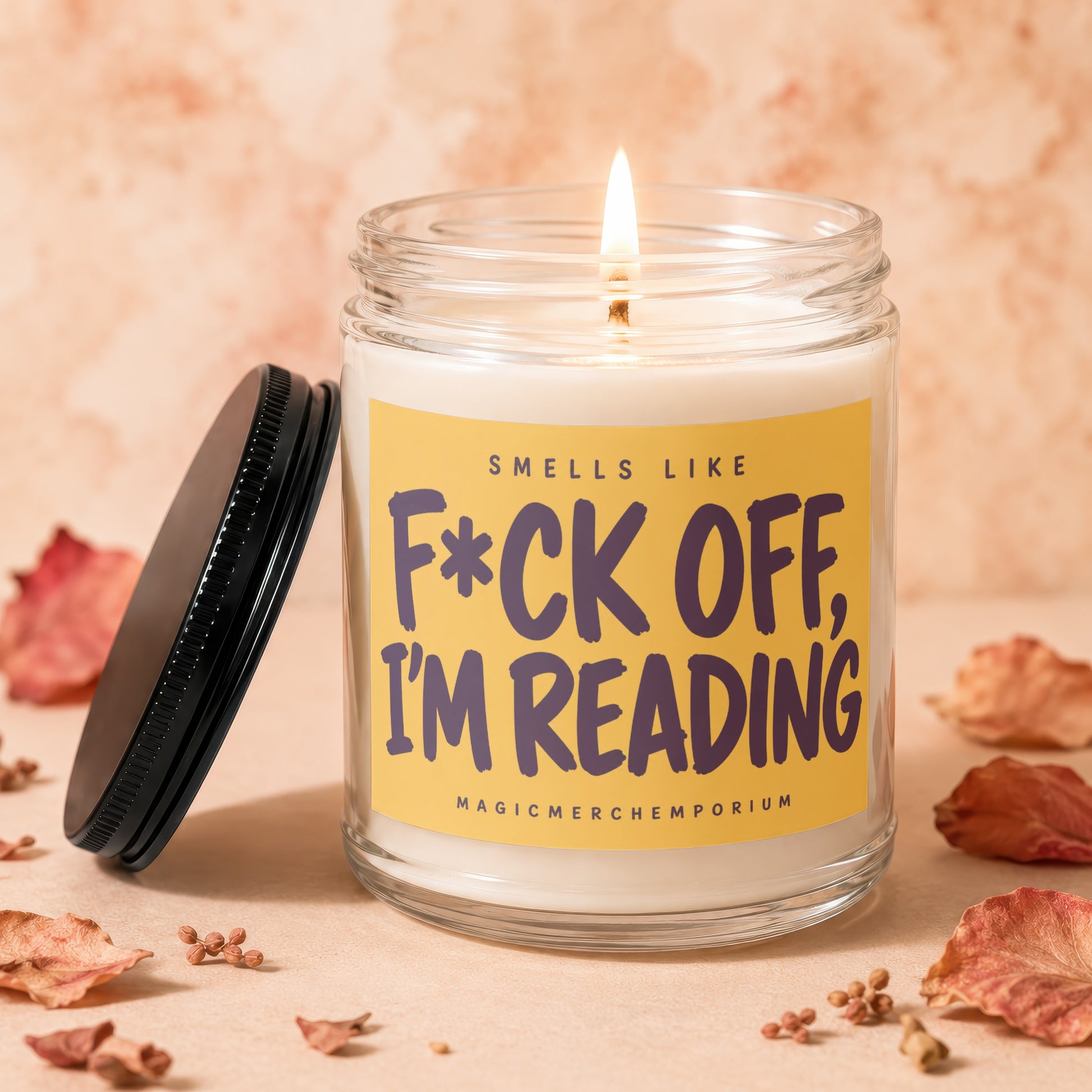 Lit candle in a jar with a yellow label that says "Smells like F*ck off, I'm reading."
