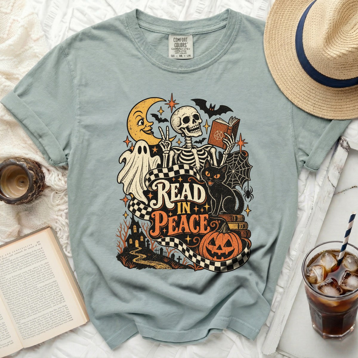 T-shirt graphic with skeleton, ghost, black cat, moon, bats, and "Read in Peace" text.