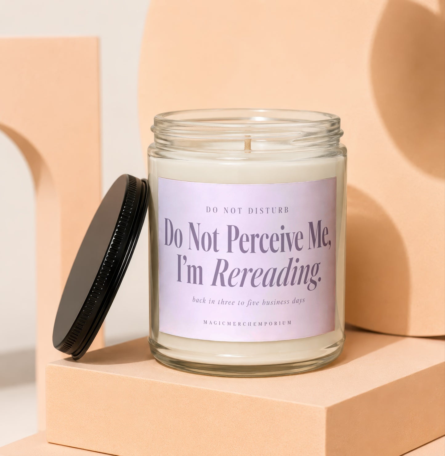Glass candle with lavender label that reads "Do Not Perceive Me, I'm Rereading."