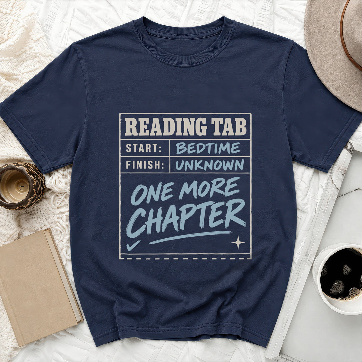 Navy t-shirt with "Reading Tab: Start Bedtime, Finish Unknown, One More Chapter" graphic.