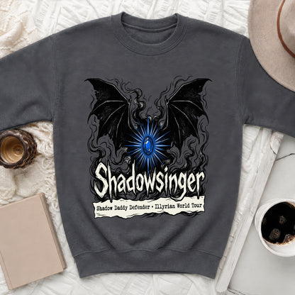 Charcoal grey crewneck sweatshirt featuring a graphic with black bat wings, a glowing blue gem, and text reading "Shadowsinger Shadow Daddy Defender Illyrian World Tour".