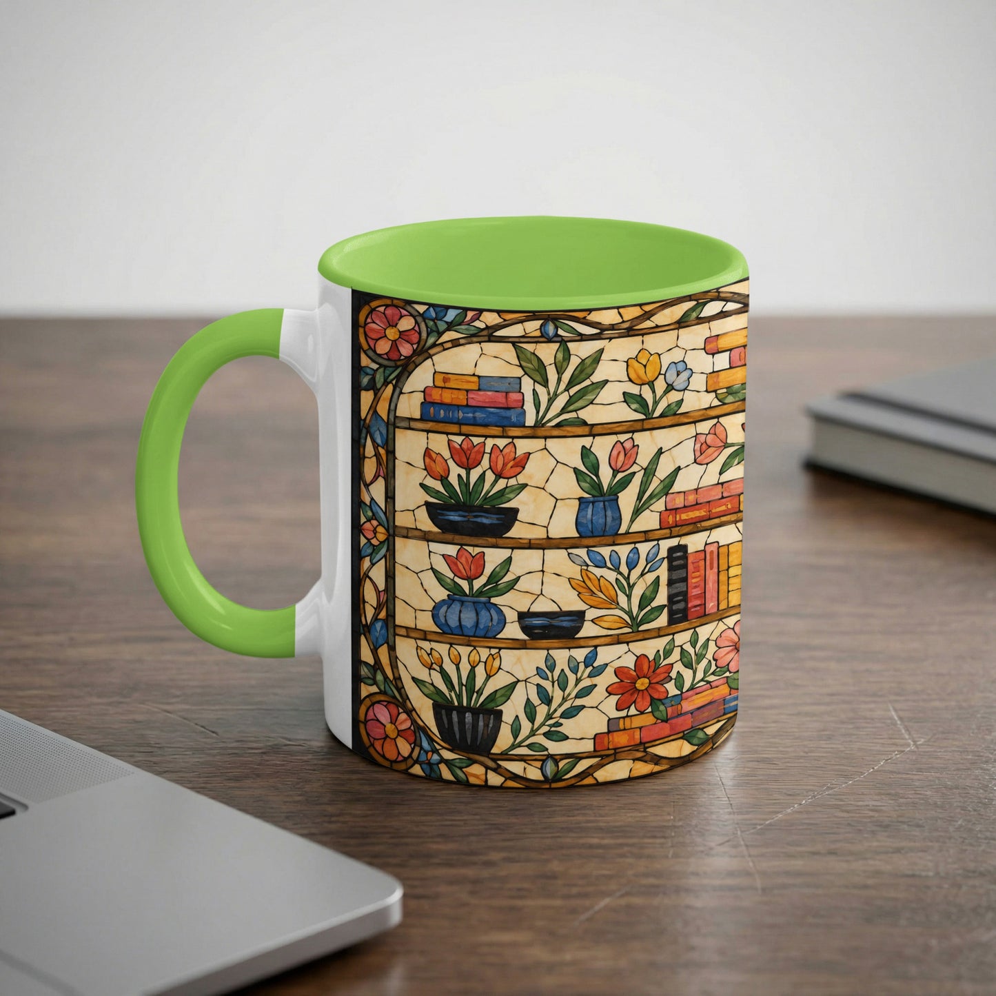 White mug with green handle featuring a stained glass design of bookshelves filled with books and flowers.