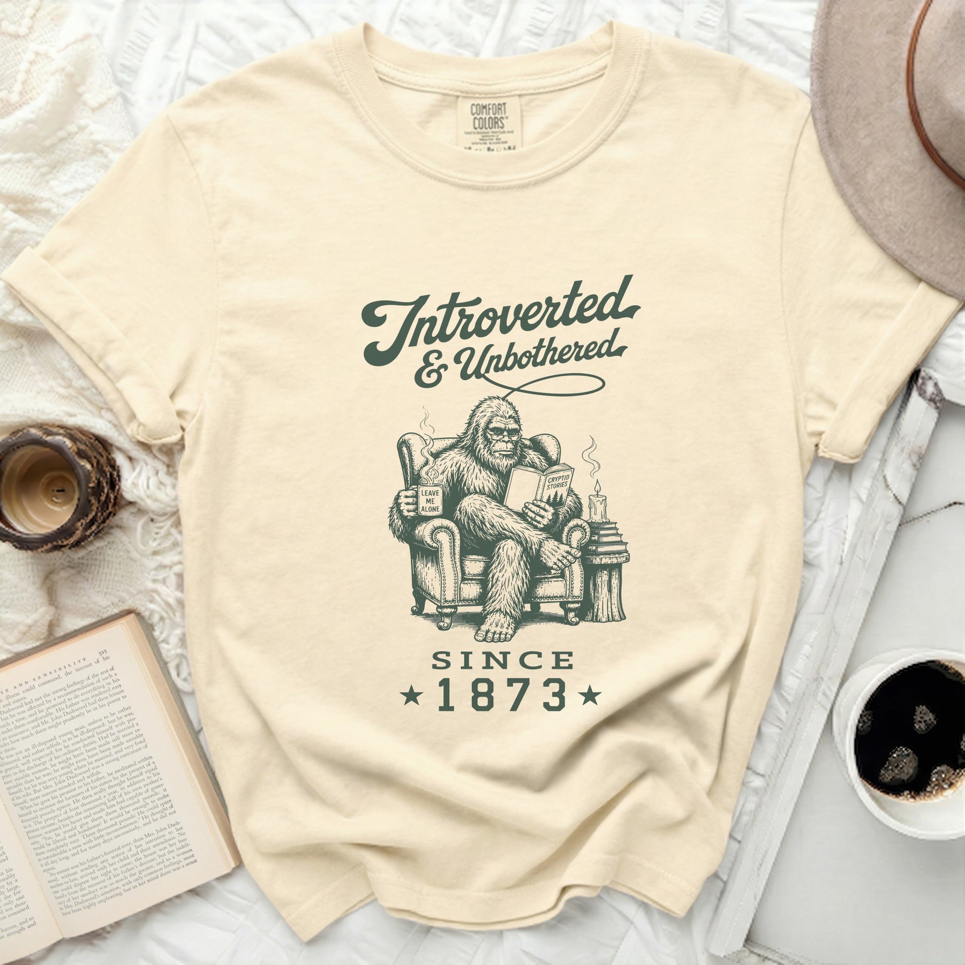 Beige Comfort Colors t-shirt with Bigfoot reading, "Introverted & Unbothered Since 1873."