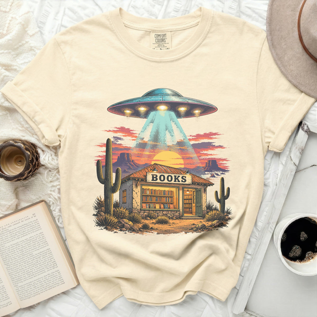 UFO beams a light onto a desert books store with cacti.