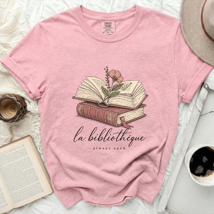 Pink t-shirt with "la bibliotheque always open" and open books graphic.