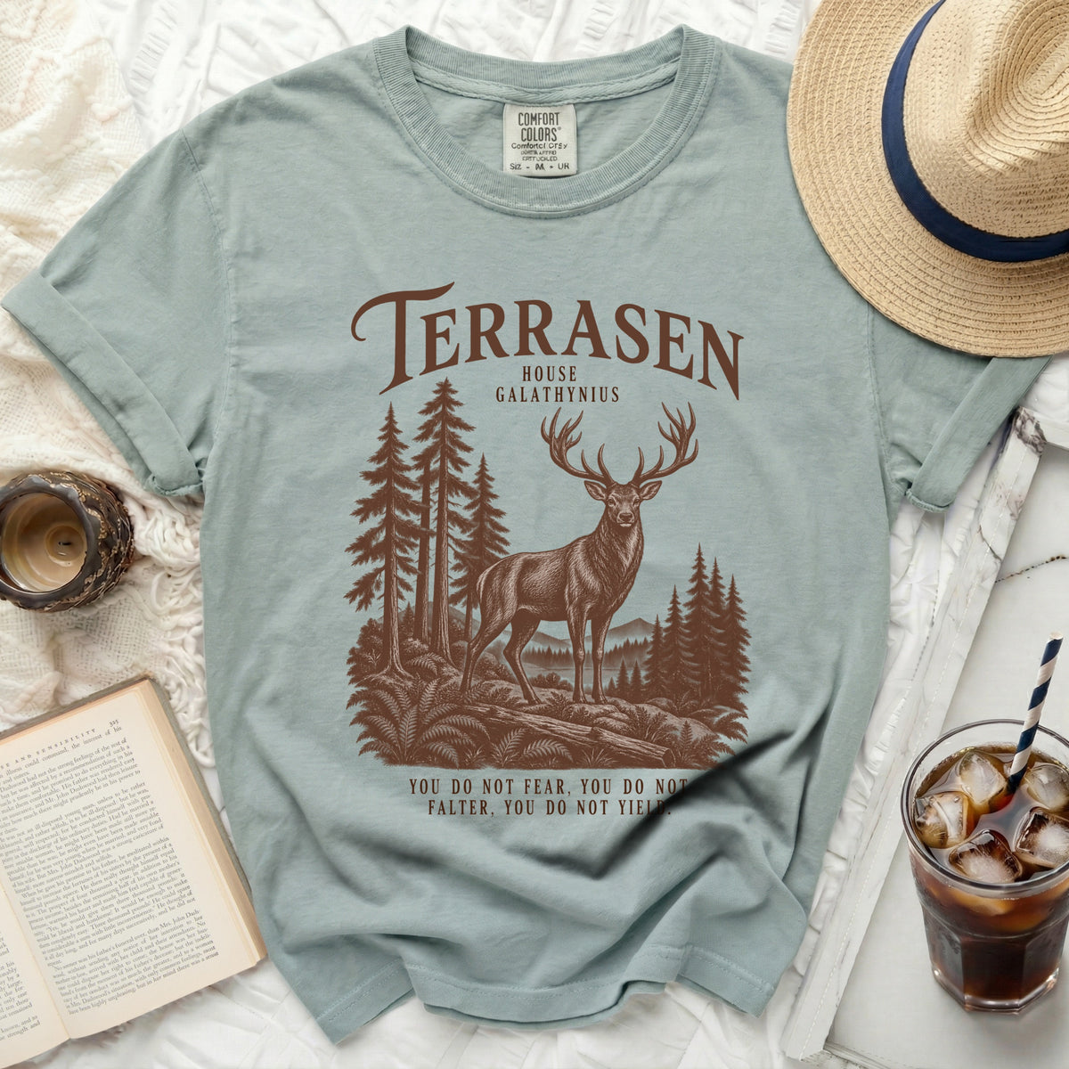 Light blue t-shirt with Terrasen House Galathynius graphic and quote.