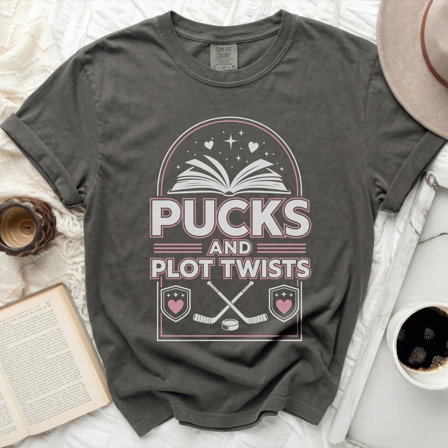 T-shirt with "Pucks and Plot Twists" text and hockey graphics.