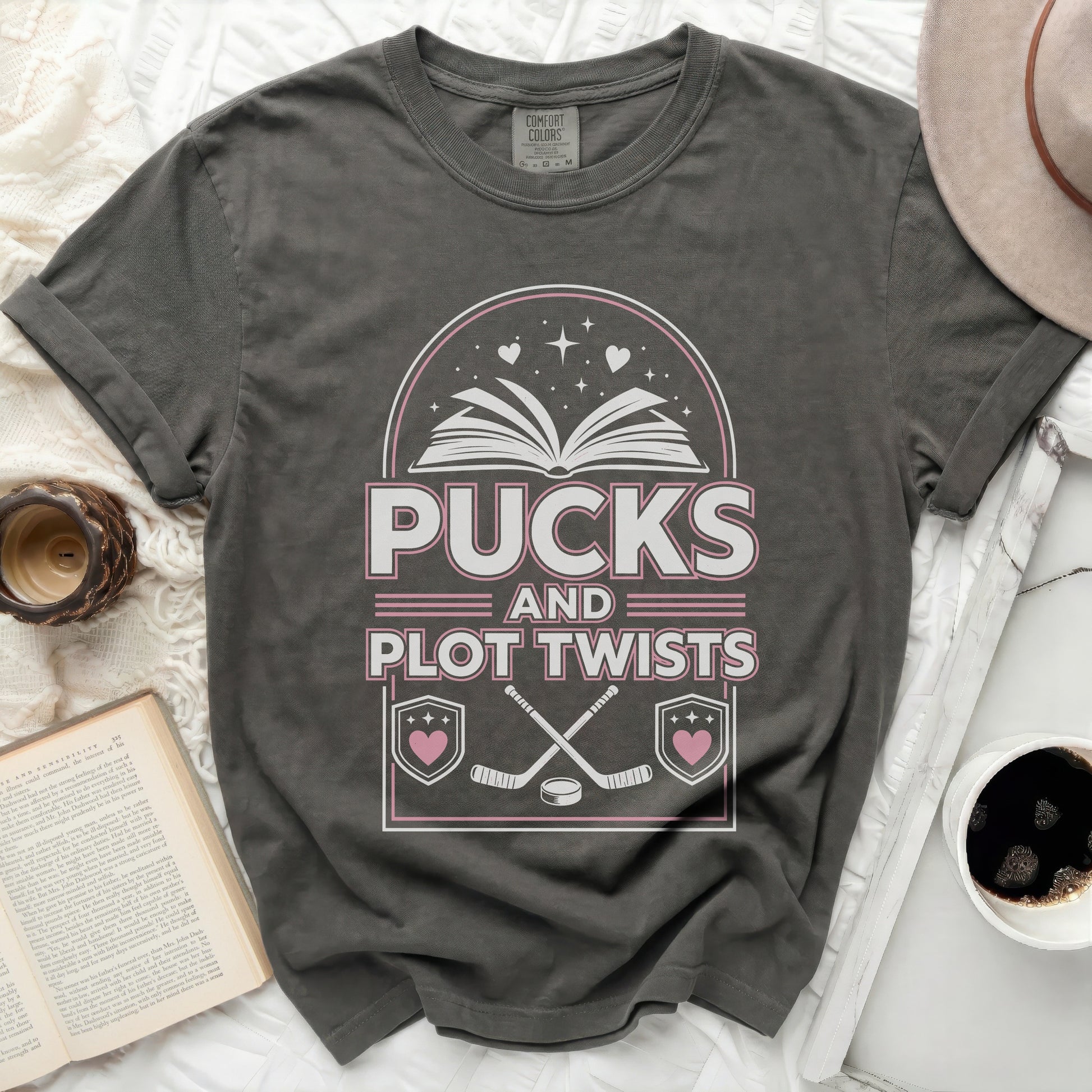T-shirt with "Pucks and Plot Twists" text and hockey graphics.