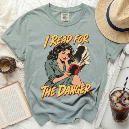 T-shirt with comic illustration of woman reading and text "I READ FOR THE DANGER."