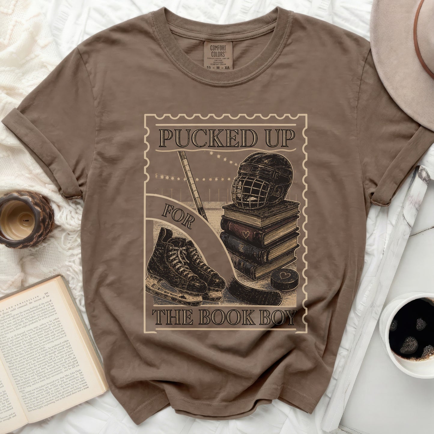 Brown t-shirt with "Pucked Up For The Book Boy" text and hockey gear graphic.