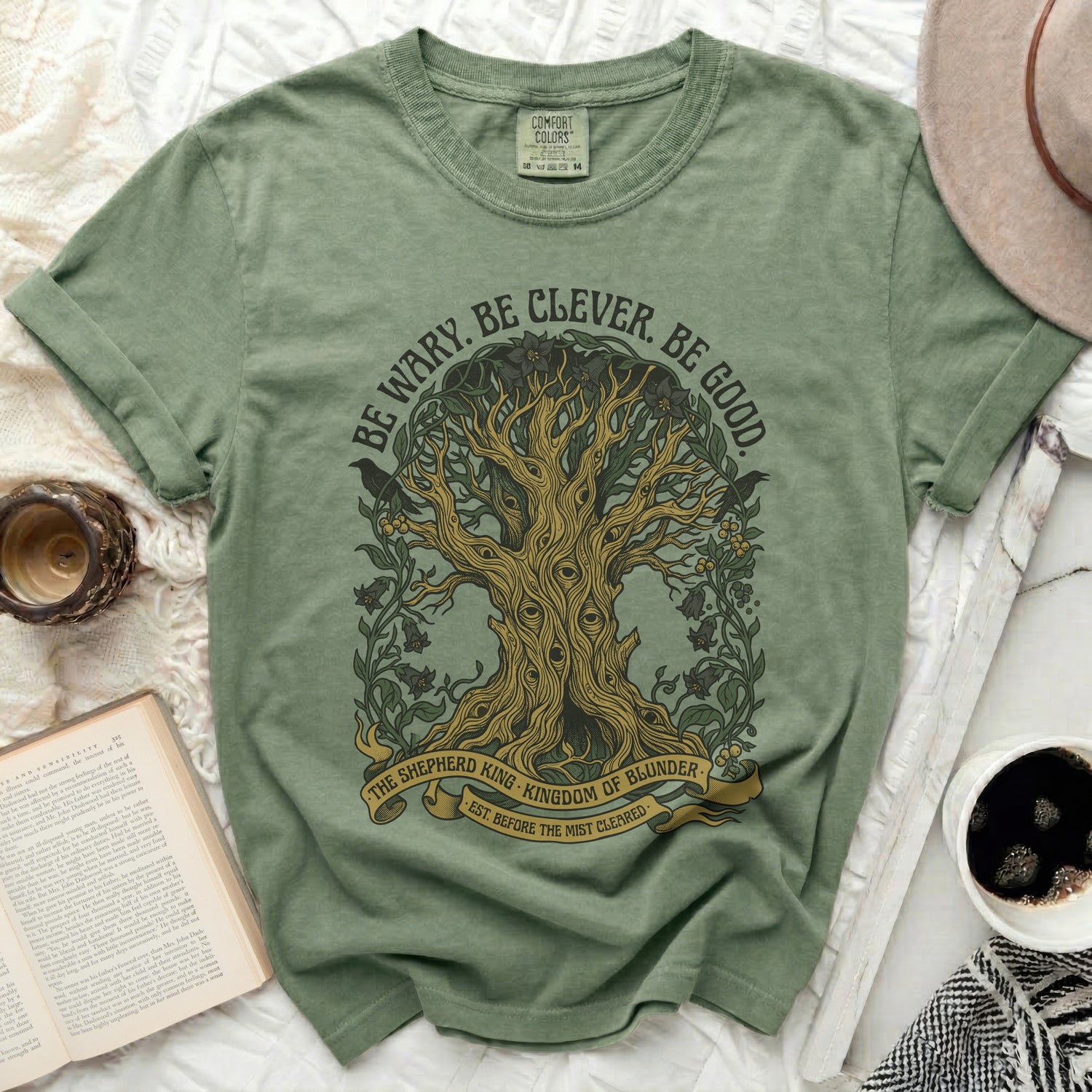 Green t-shirt with tree of eyes graphic and text "Be Wary. Be Clever. Be Good."