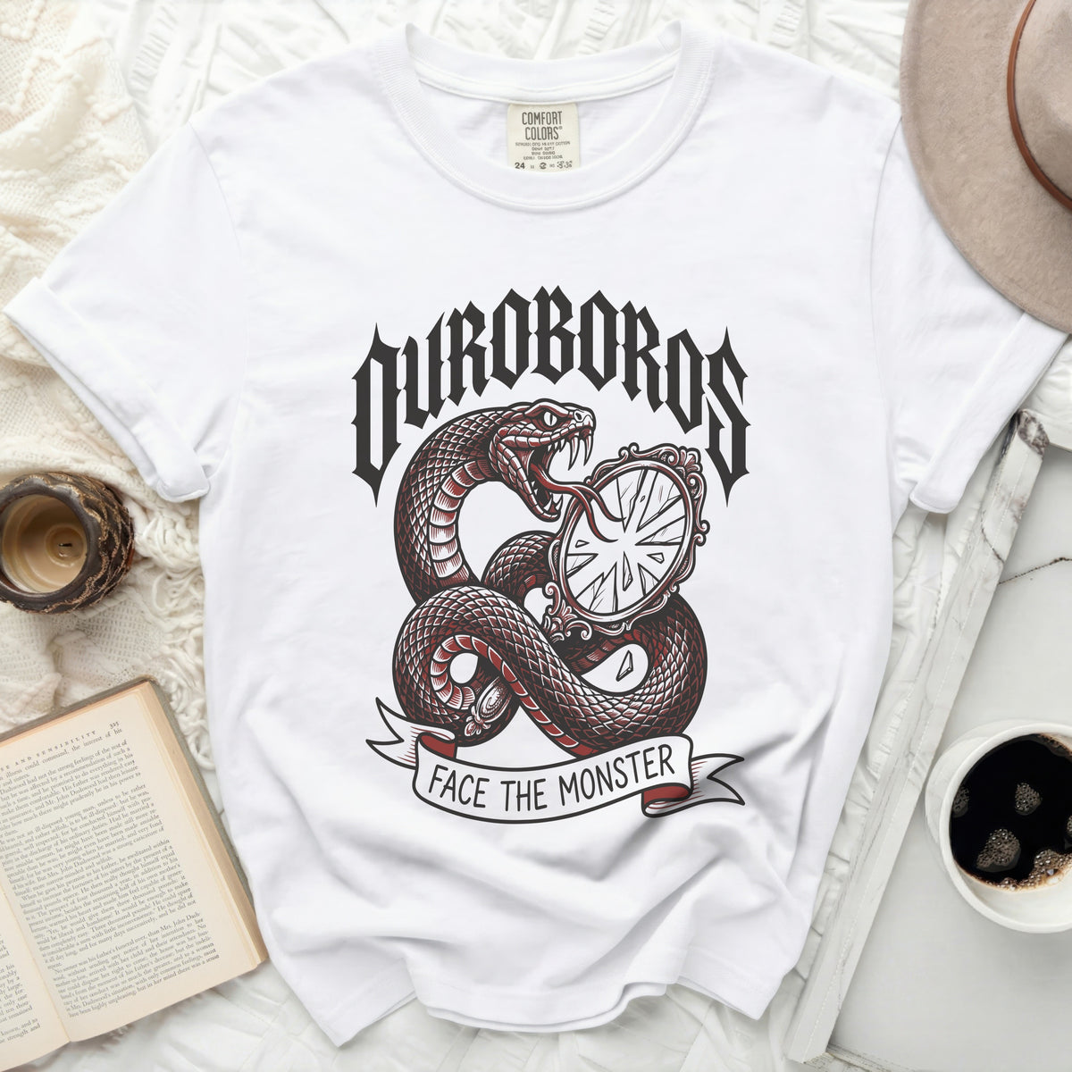 White t-shirt with a snake coiled around a cracked mirror, text reads OUROBOROS FACE THE MONSTER.