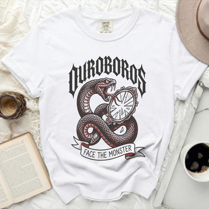White t-shirt with a snake coiled around a cracked mirror, text reads OUROBOROS FACE THE MONSTER.