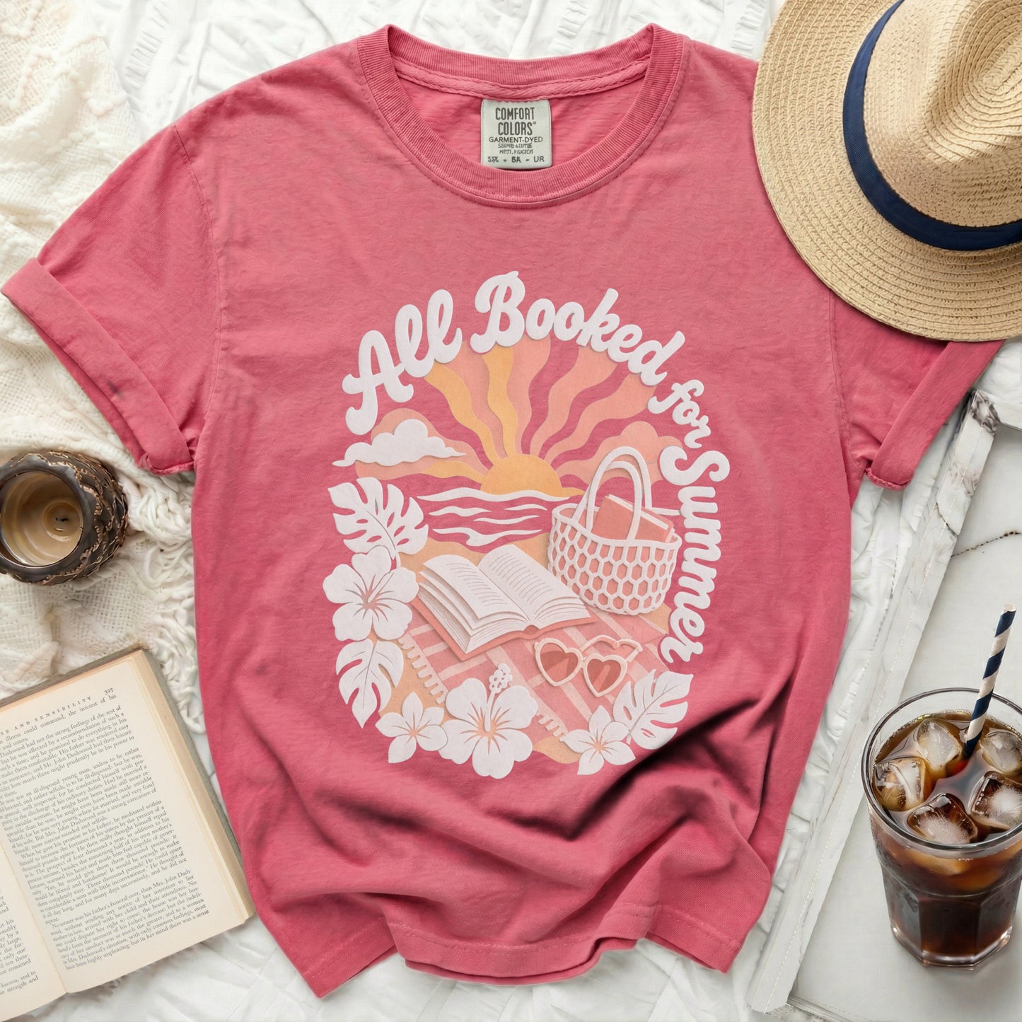 Pink t-shirt with "All Booked for Summer" text and beach-themed graphic.