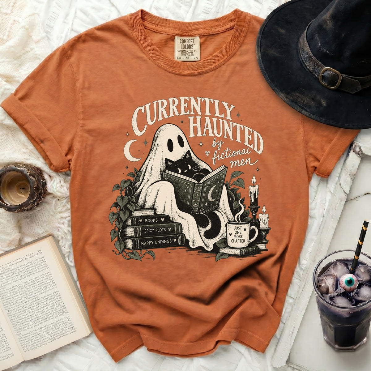Orange t-shirt with ghost, black cat, and books design reading "Currently Haunted by Fictional Men".