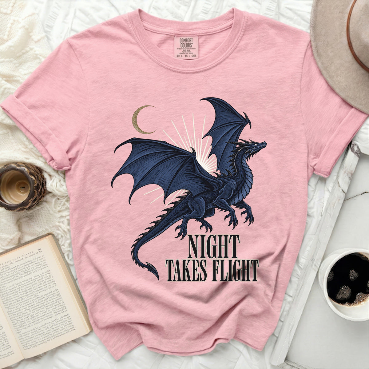 Pink t-shirt with a dark blue dragon graphic and "NIGHT TAKES FLIGHT" text.