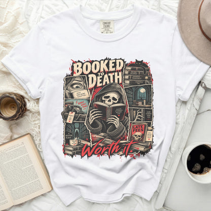White t-shirt with "Booked to Death" graphic featuring a skeleton reading and books.