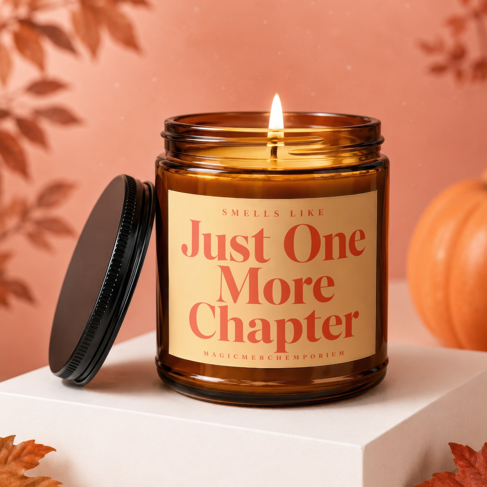 Brown jar candle with lit flame, reads "Just One More Chapter".