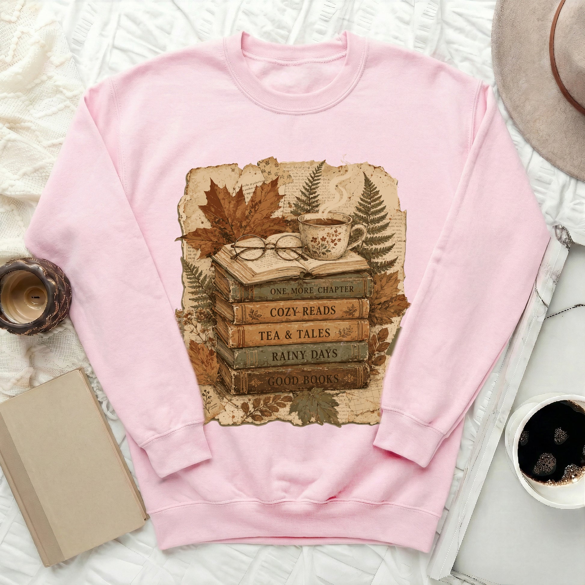 Pink sweatshirt with stacked books graphic: "One More Chapter," "Cozy Reads."