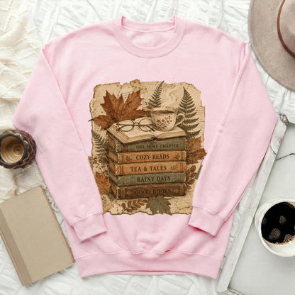 Pink sweatshirt with stacked books graphic: "One More Chapter," "Cozy Reads."