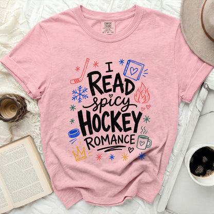 Pink t-shirt with "I read spicy hockey romance" and winter icons.