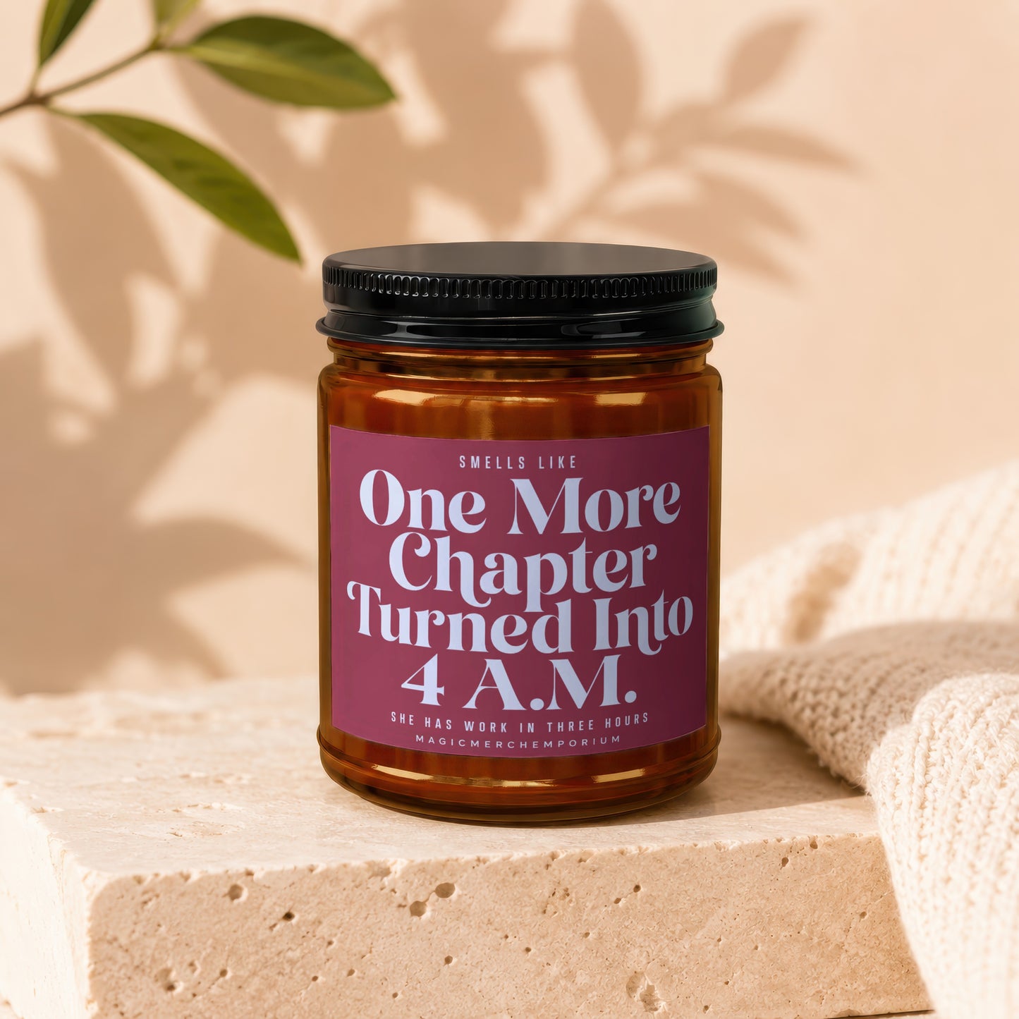 Candle with text "One More Chapter Turned Into 4 A.M." on a textured surface.