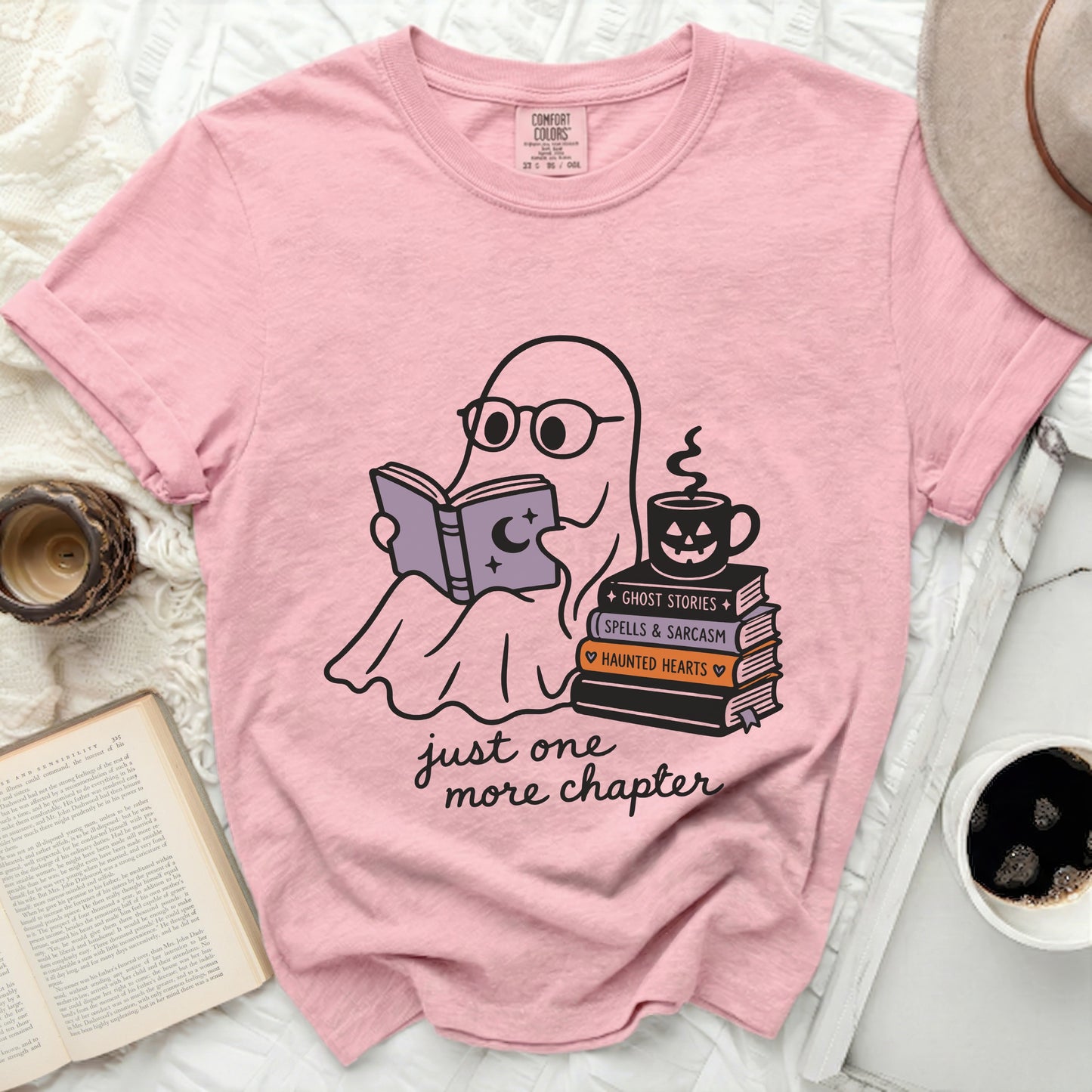 Pink t-shirt with a graphic of a ghost reading, books, coffee, and text.