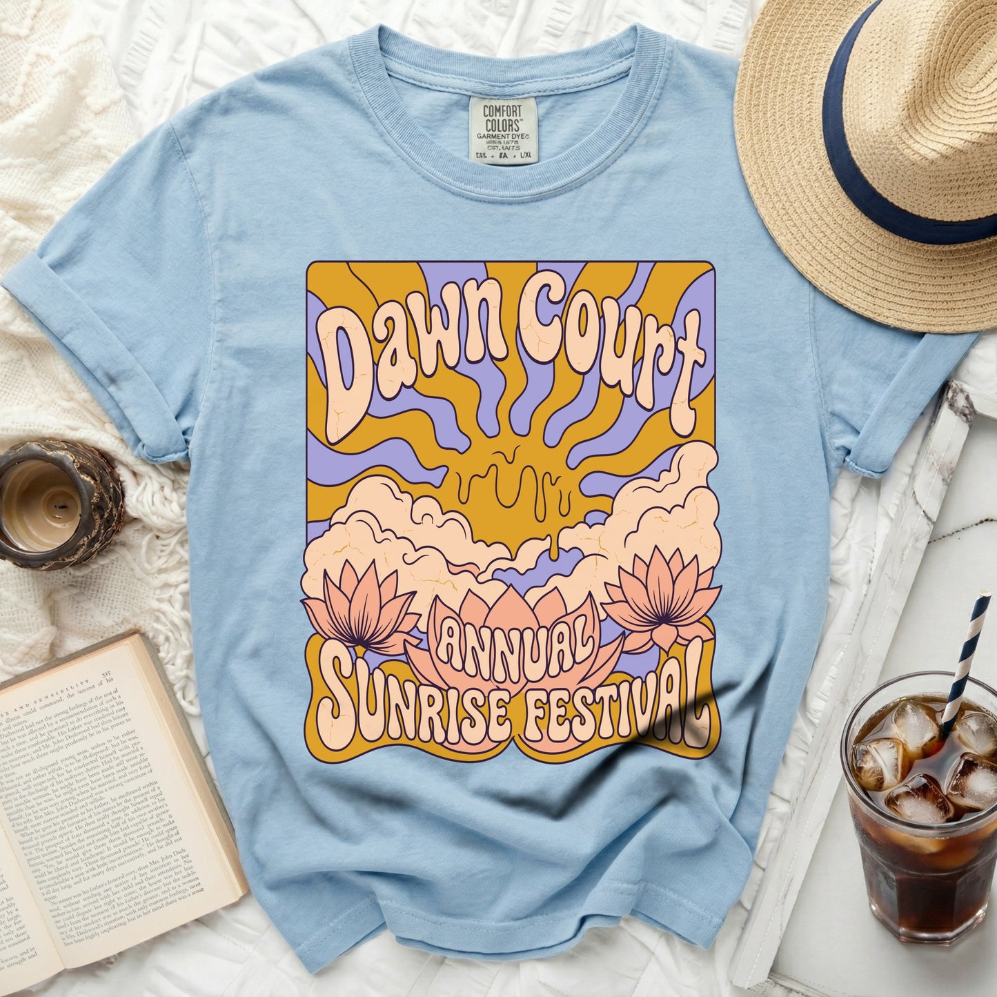 Light blue t-shirt with "Dawn Court Annual Sunrise Festival" graphic featuring lotus flowers.
