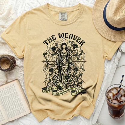 Yellow t-shirt with The Weaver graphic, spiderwebs, and quote "SHE IS ALWAYS SPINNING DO NOT RUN".